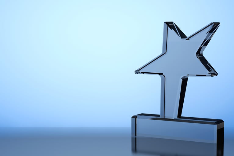 a glass star-shaped trophy with a blue backlight